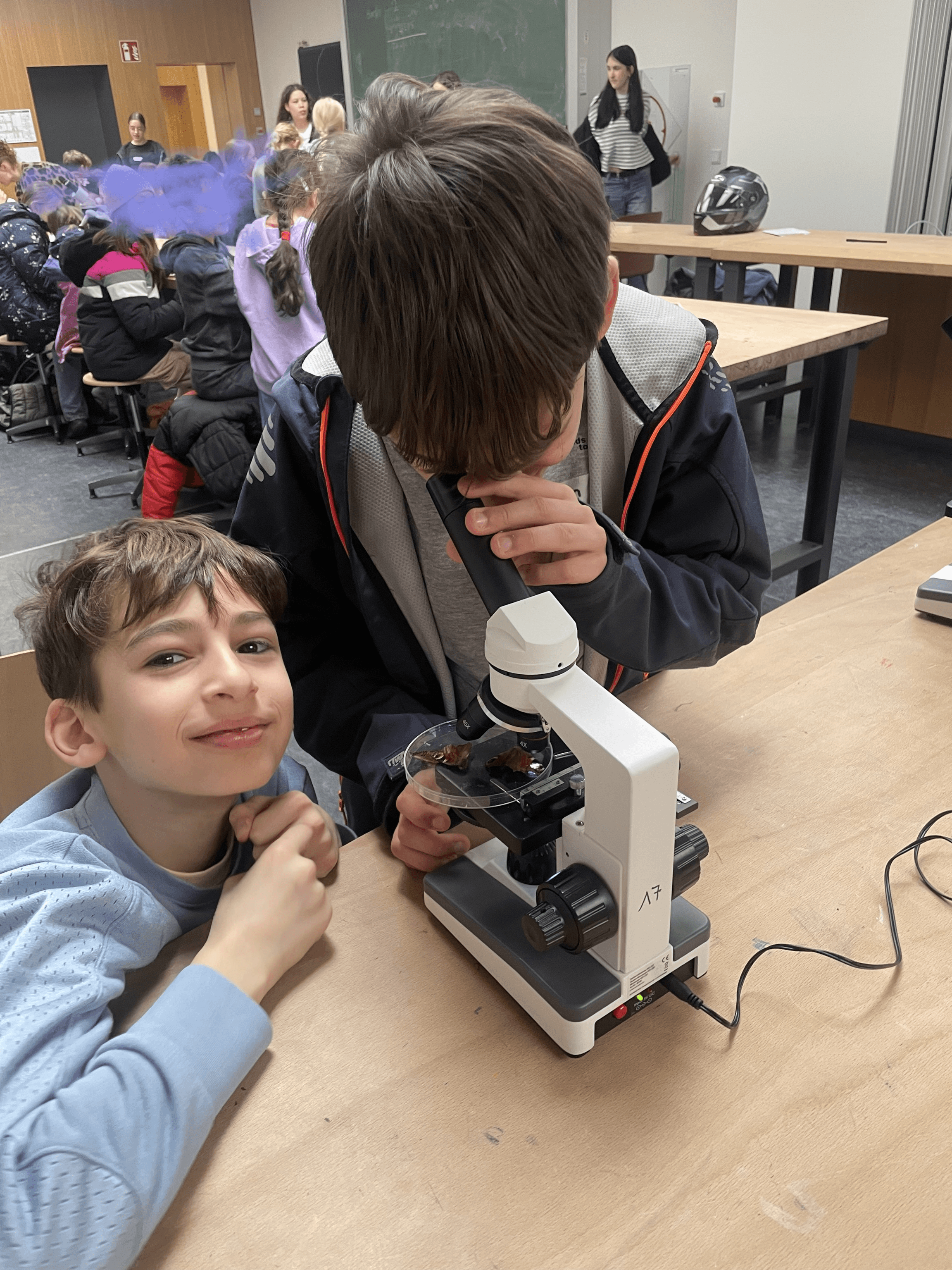 zwei Jungen arbeiten mit einem Mikroskop