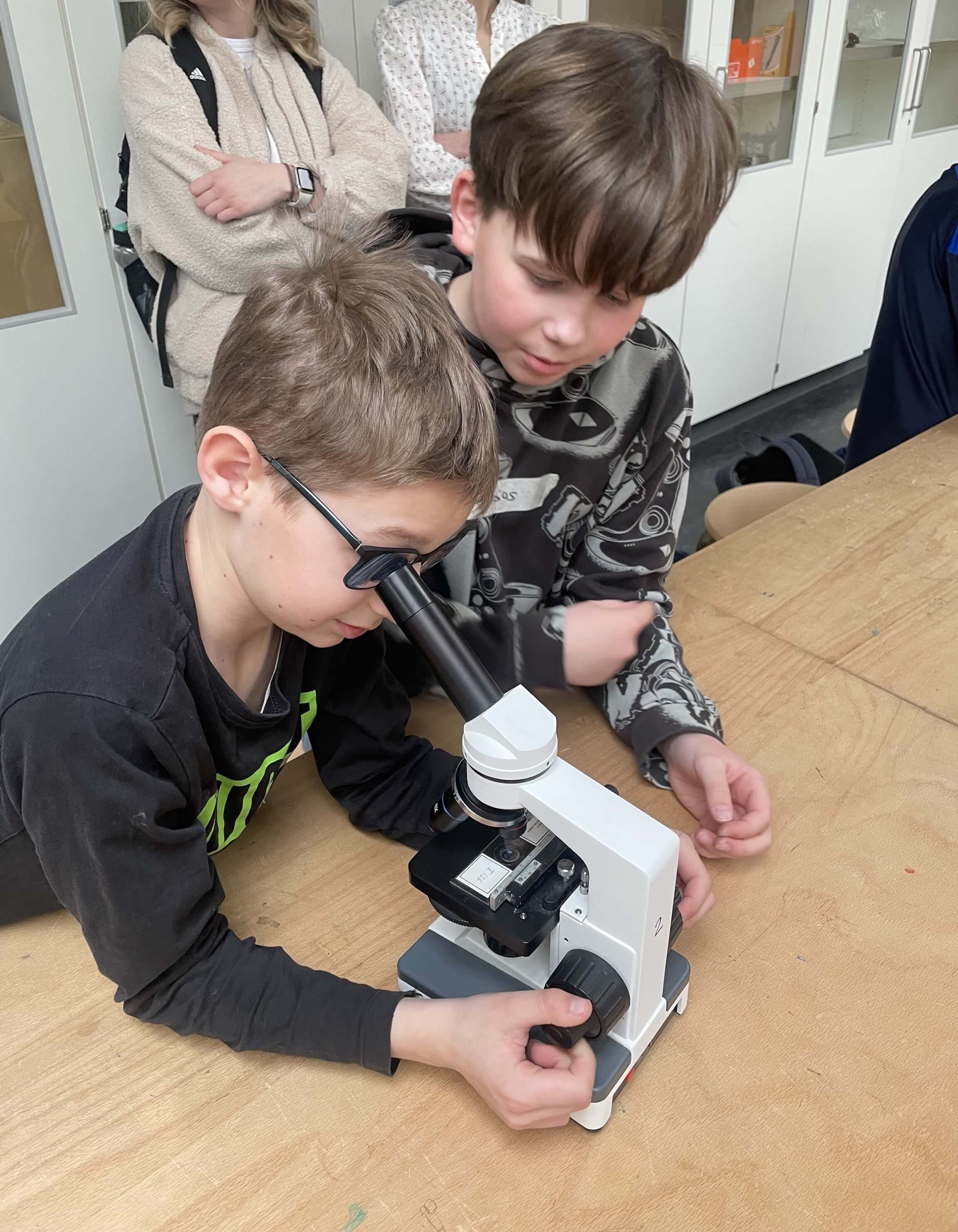 zwei Jungen arbeiten mit einem Mikroskop